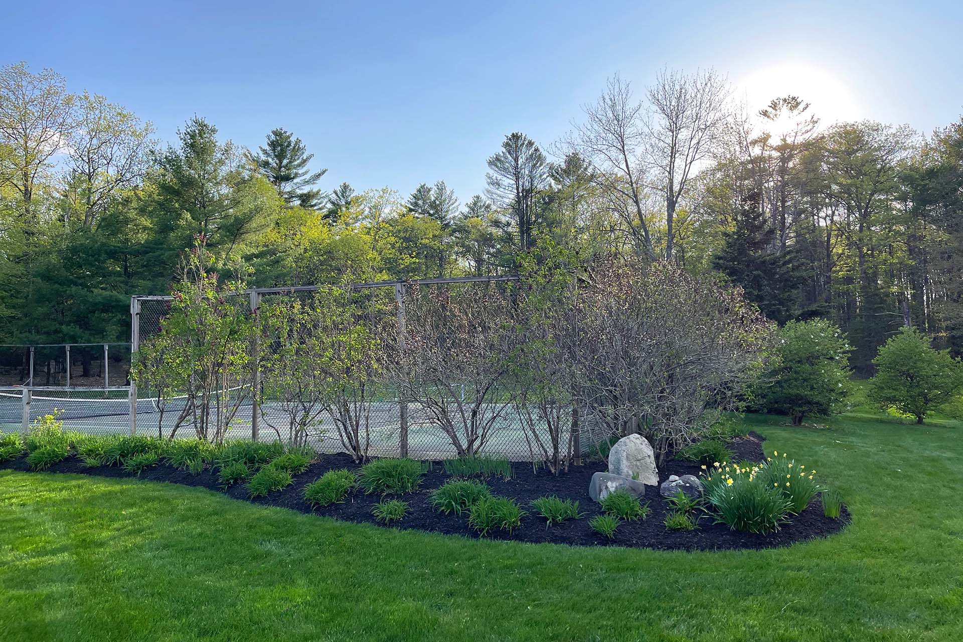A tennis court with freshly laid mulch for mulching service and landscaping near me