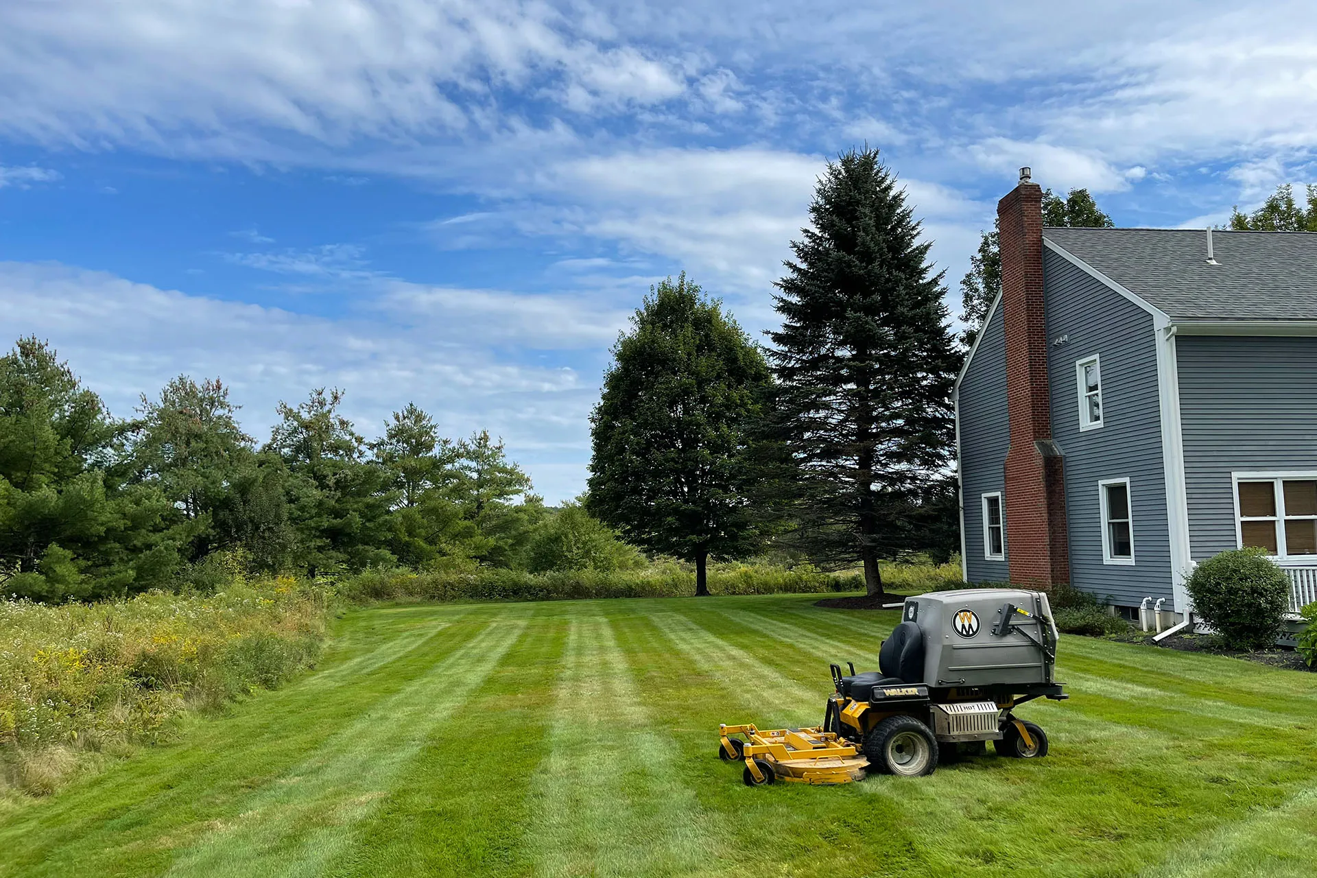 A large commercial lawn mower sitting on a freshly mowed lawn near me