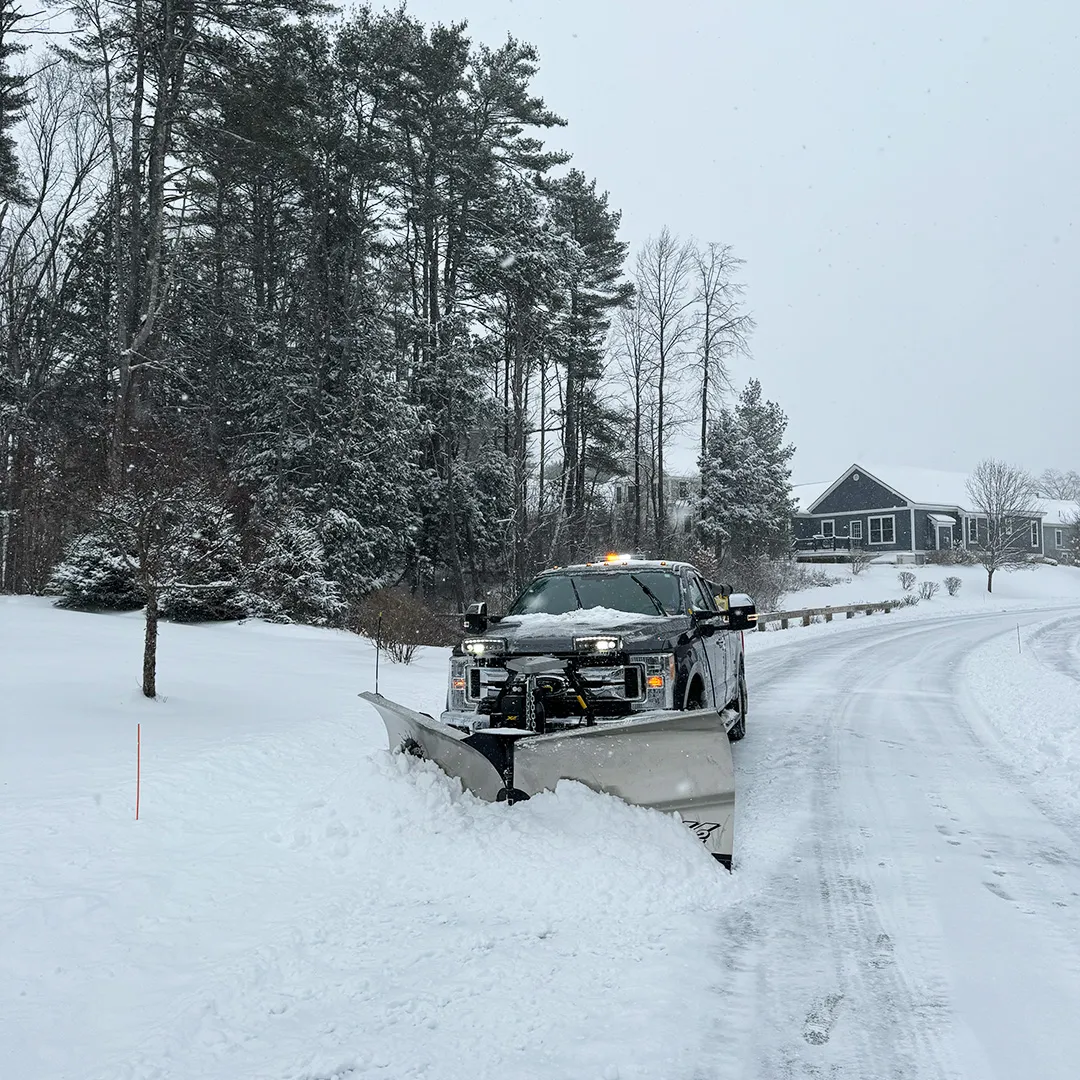 Picture of a truck plowing a driveway for snow removal service near me